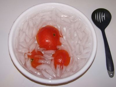 Tomatoes cooling in ice water after heating to remove their skins